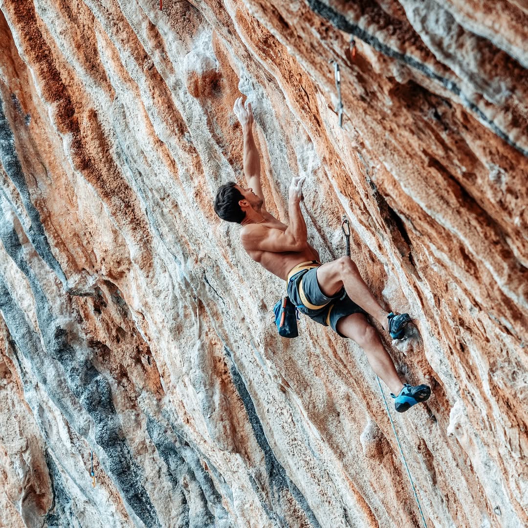 Guida alpina in arrampicata su parete rocciosa