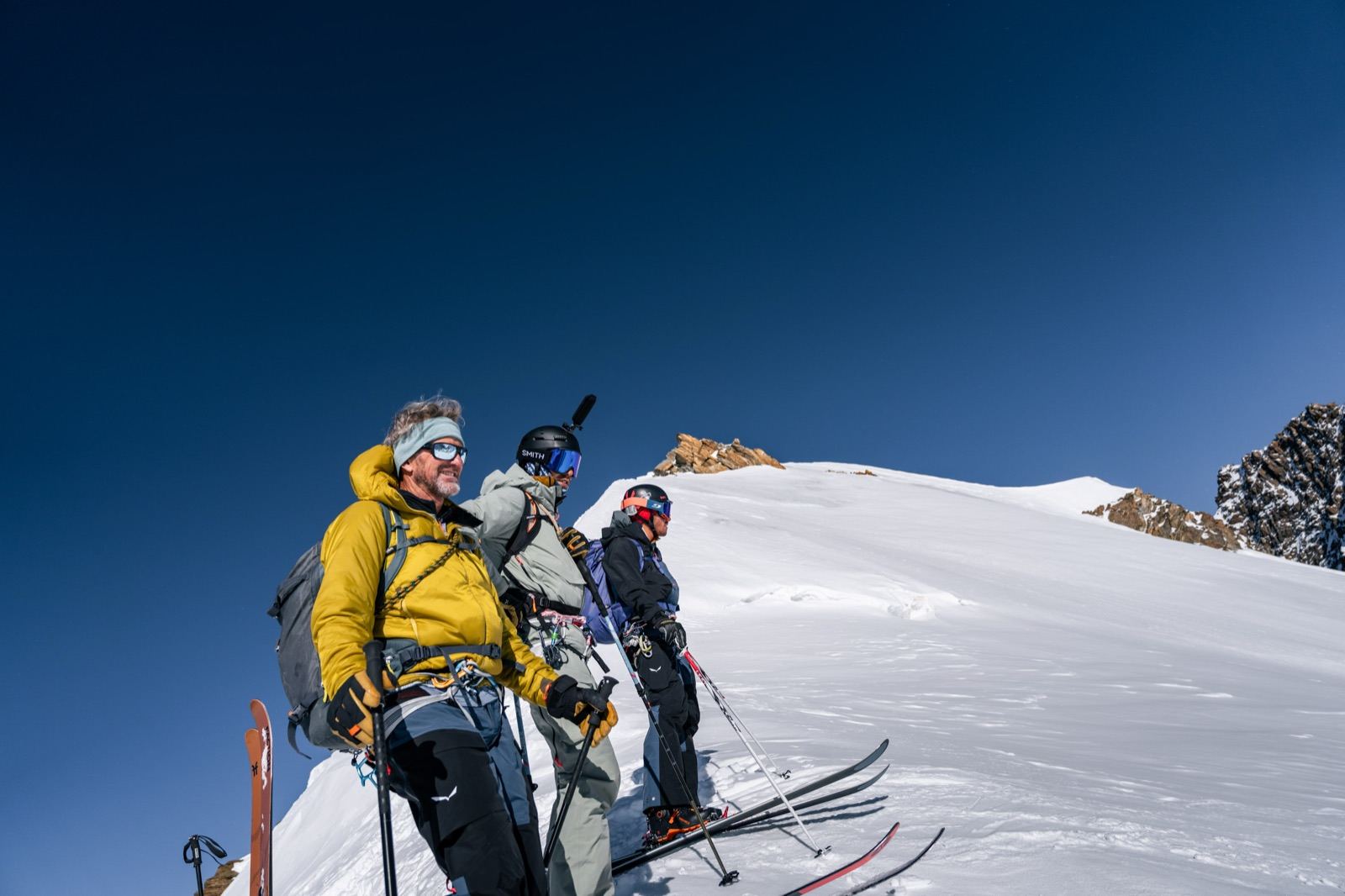 Tre sciatori pronti a partire sul pendio in quota